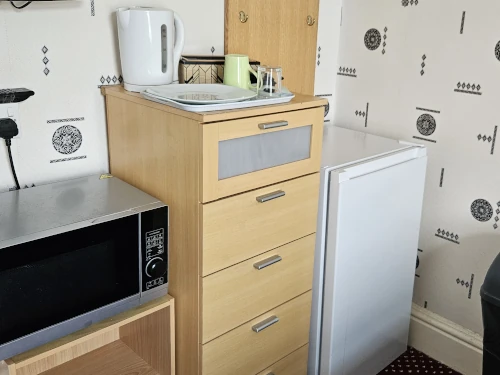 Tea-making facilities, tall chest of drawers and a fridge for storage